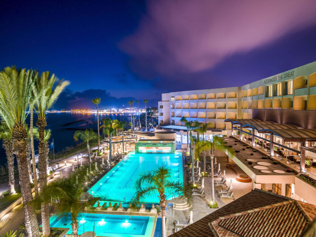 Exterior of Alexander The Great Beach Hotel with outdoor pool at night