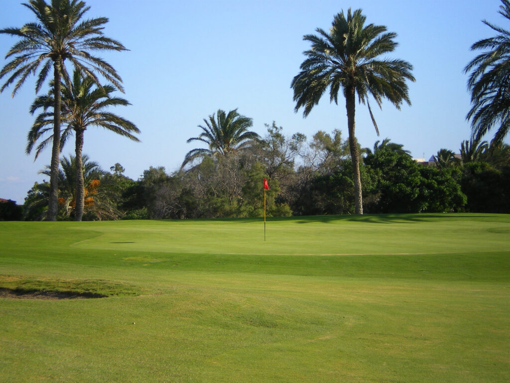 A hole with a red flag at Almerimar Golf Course