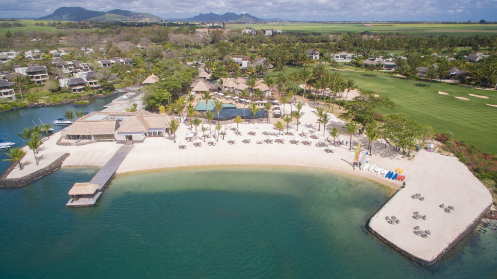 Aerial view of the beach at Anahita Golf Course with palm trees and buildings around