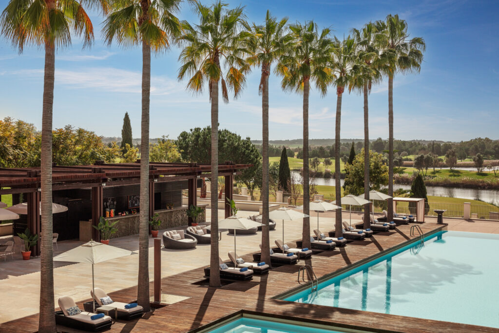 Outdoor pool with sun loungers and palm trees at Anantara Vilamoura