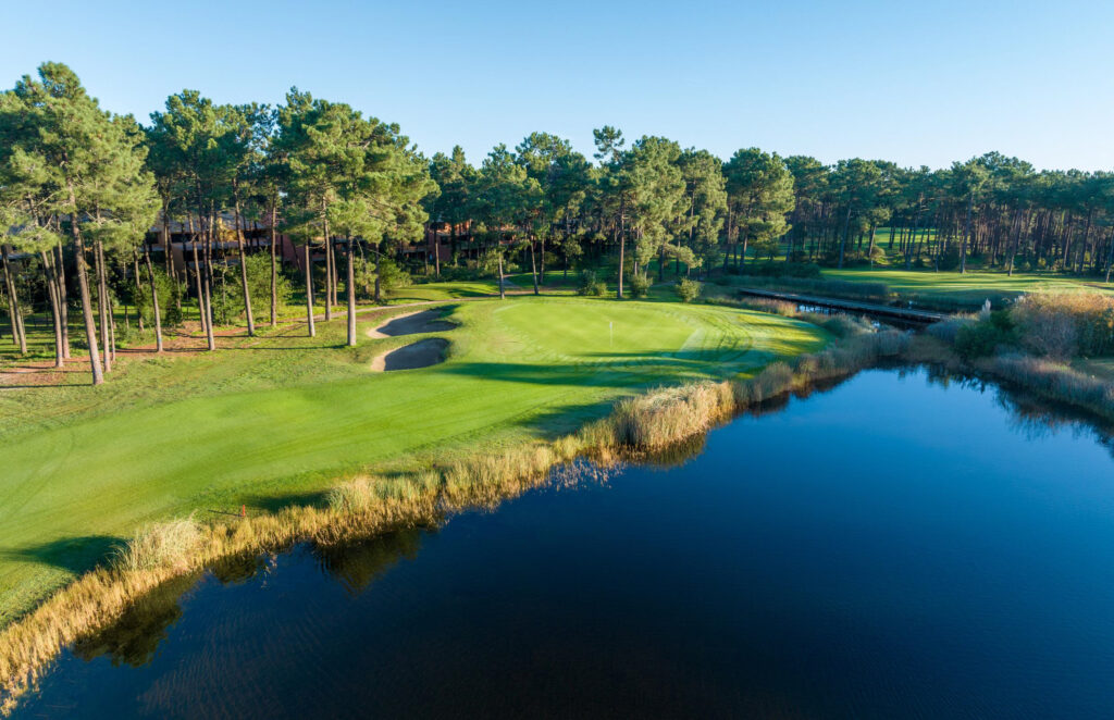 Lake with a hole and trees in background at Aroeira Challenge Golf Course