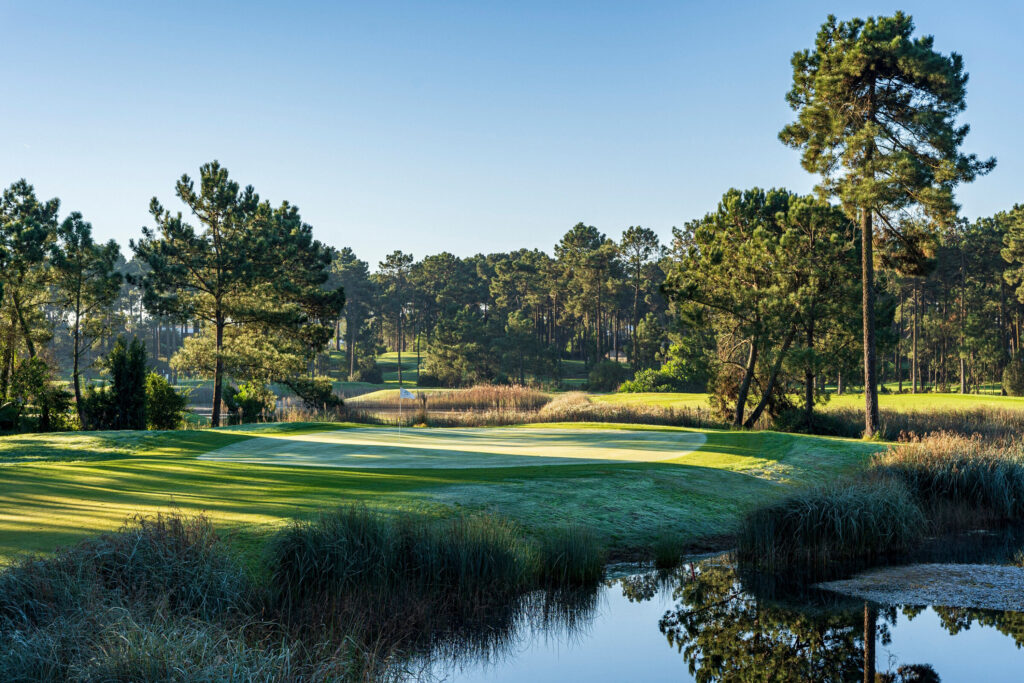 A hole with a lake and trees around at Aroeira Challenge Golf Course