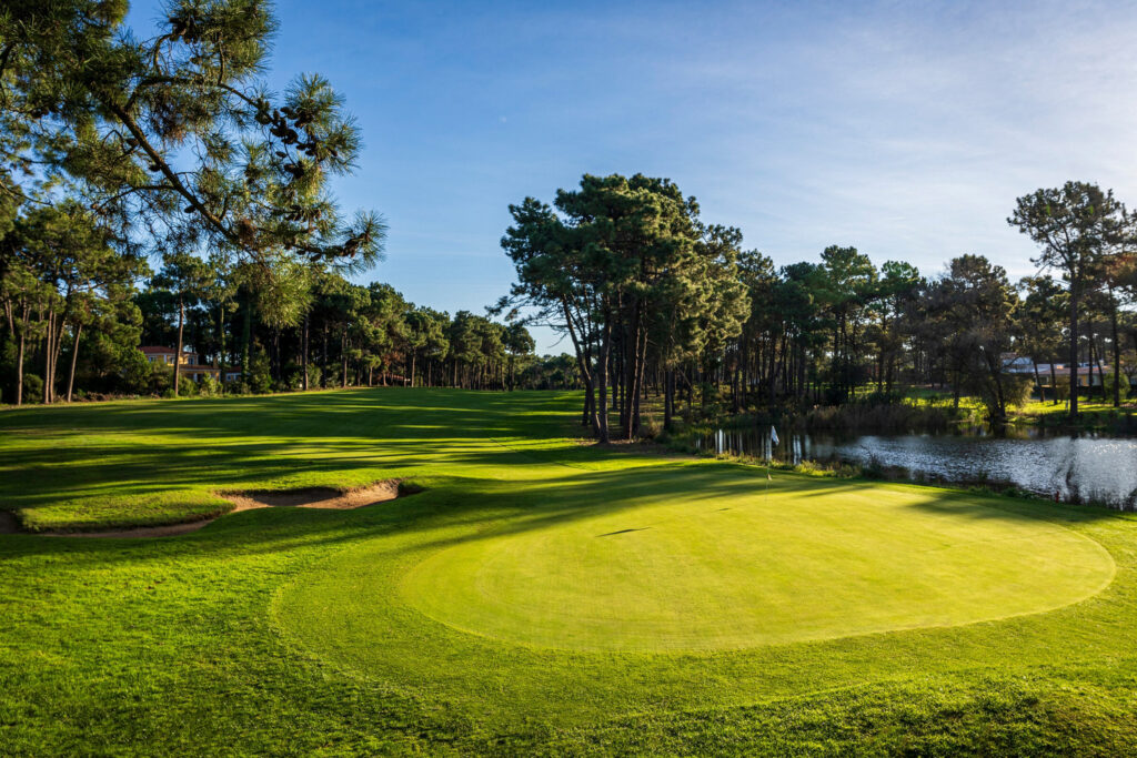 A hole with a bunker and a lake next to it at Aroeira Pines Classic Golf Course