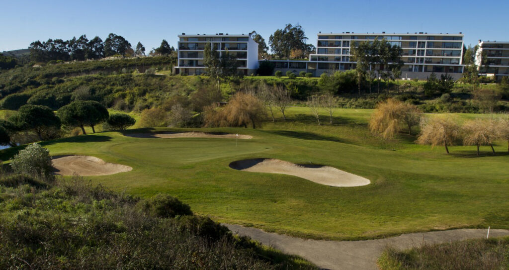 Hole with bunkers and buildings in background at Belas Clube de Campo Golf Course