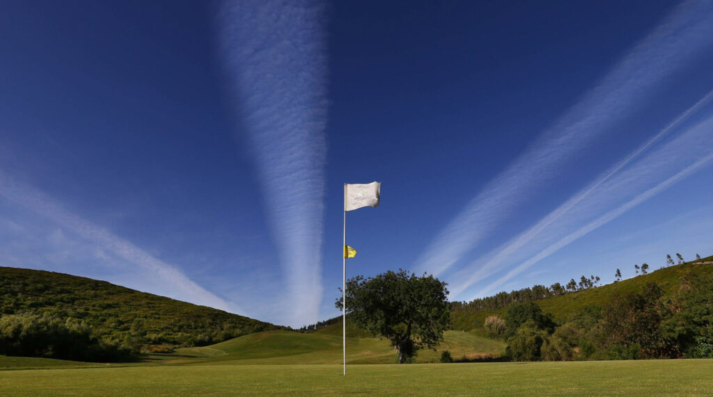 Flag with hills in background at Belas Clube de Campo Golf Course