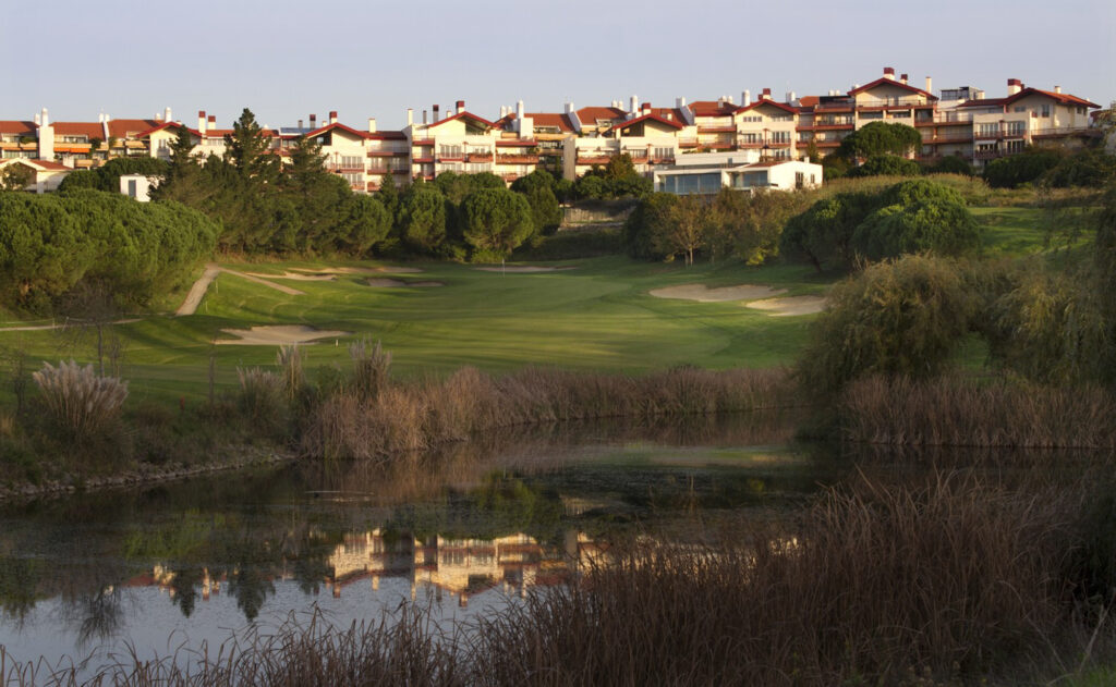 Lake with hole in background with bunkers around it at Belas Clube de Campo Golf Course