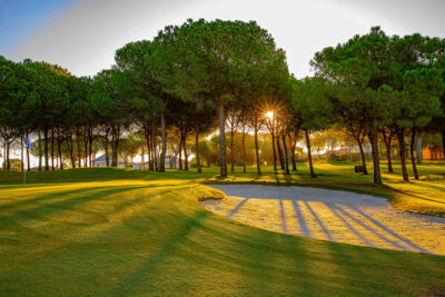 Hole with bunker and trees around at Bellavista Golf Course at sunset