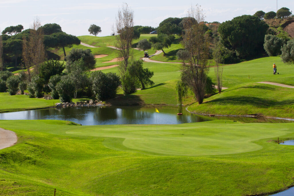 Hole with pond in background with trees around at Cabopino Golf Course