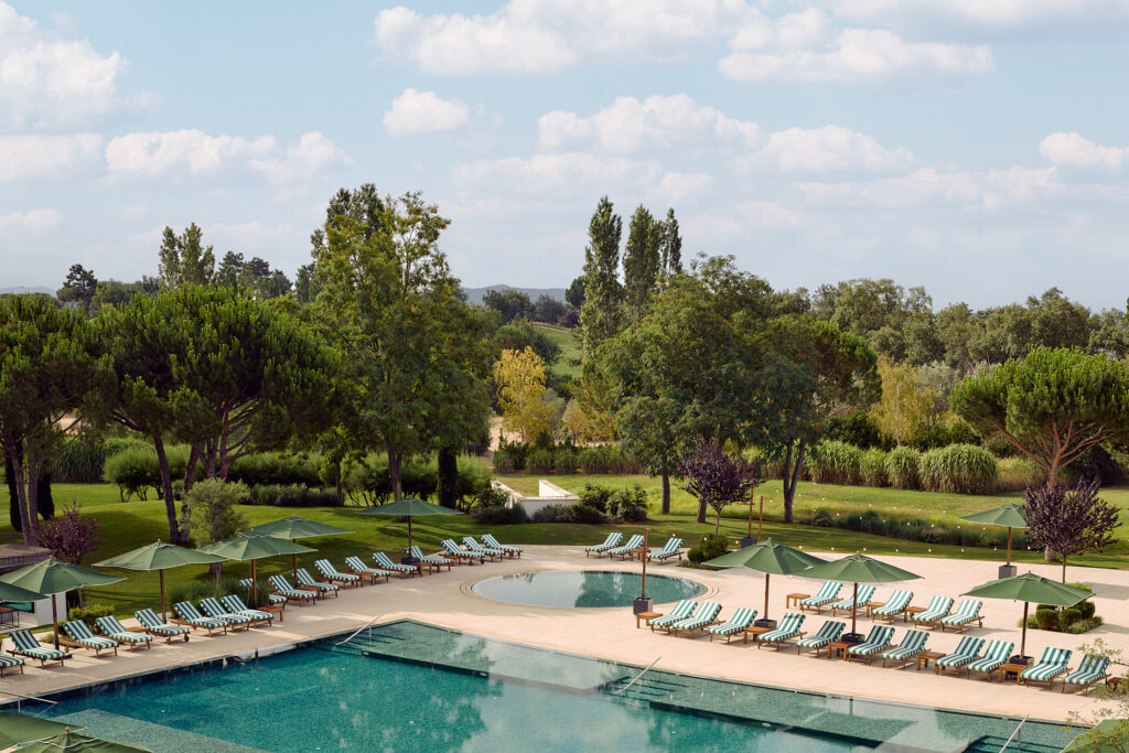 Outdoor pool with sun loungers at Camiral Golf & Wellness