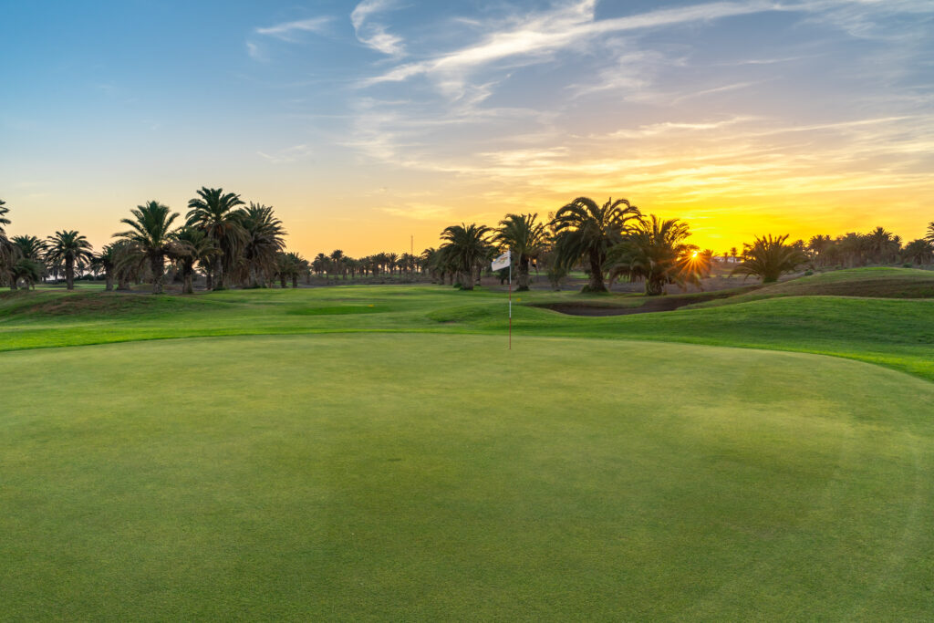 Hole with trees around at Costa Teguise Golf at sunset