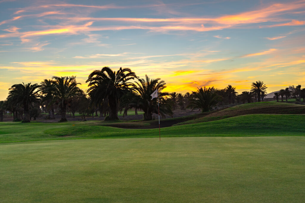 Hole with trees in background at Costa Teguise Golf at sunset