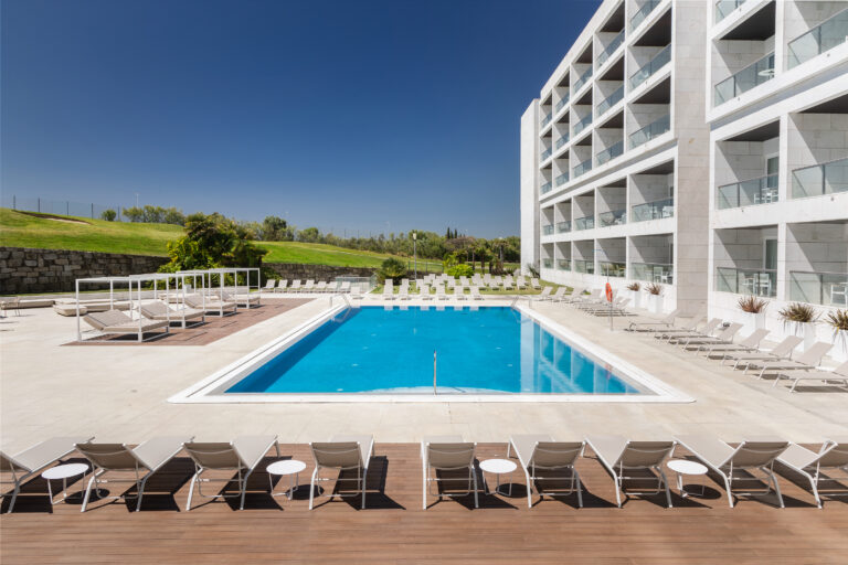 Outdoor pool with sun loungers at Crowne Plaza Caparica Lisbon