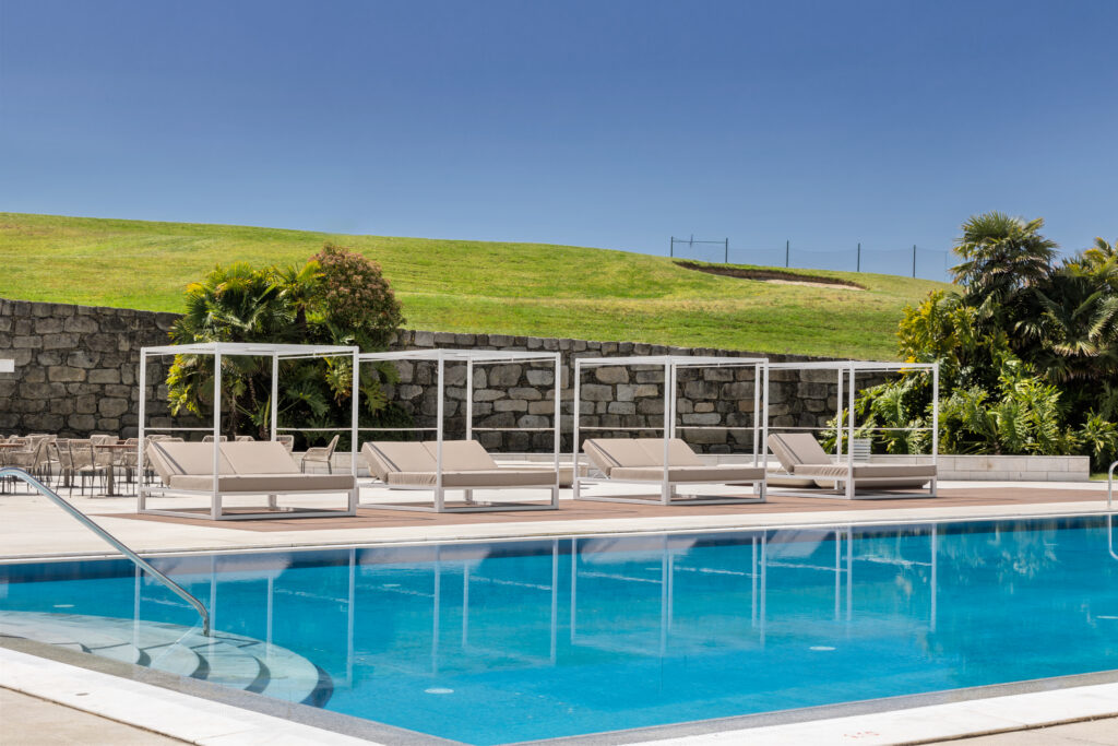 Outdoor pool with sun beds at Crowne Plaza Caparica Lisbon