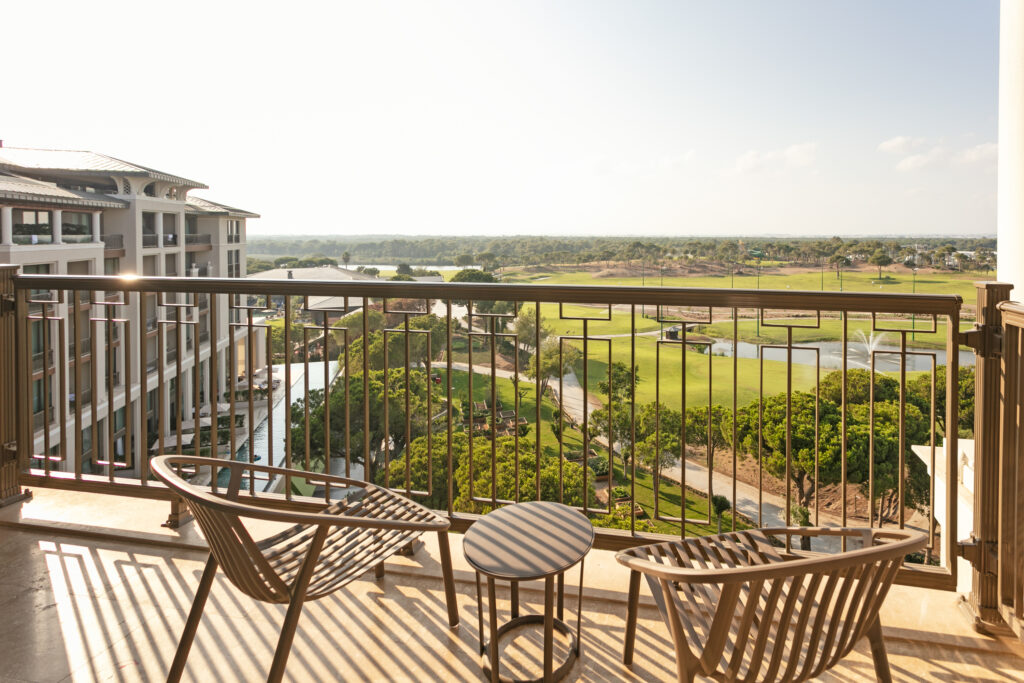 views of the golf course from a bedroom balcony with two chairs to relax & take in the scenery