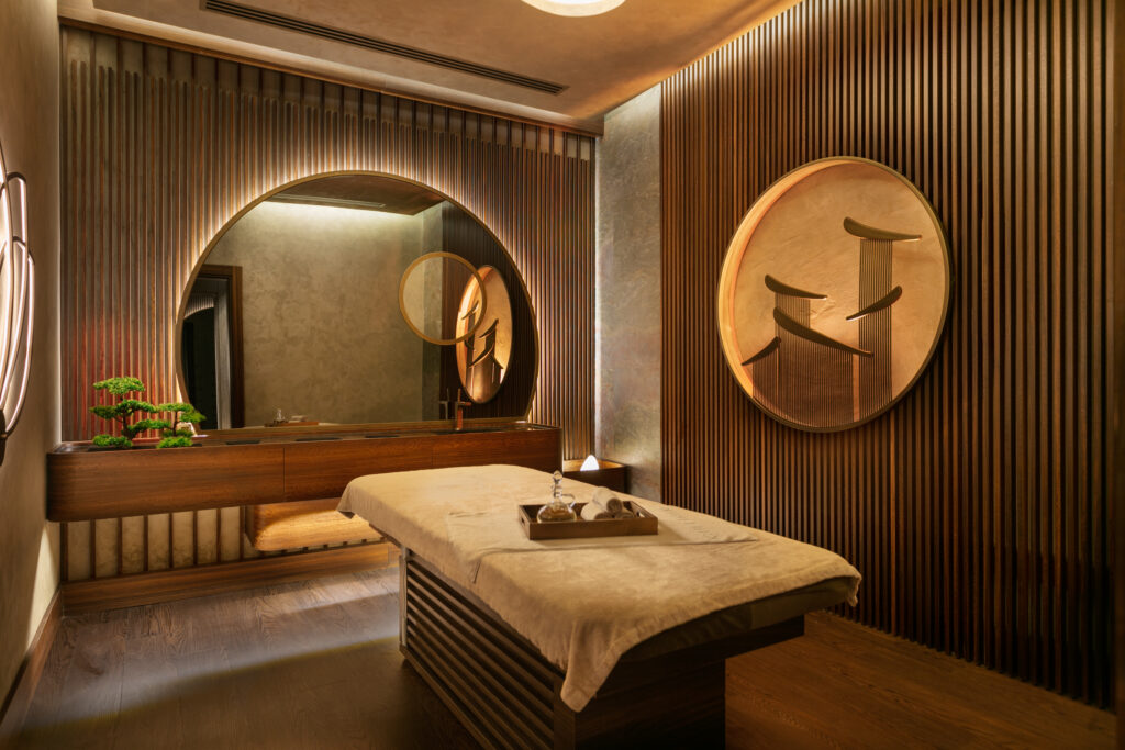 Spa treatment room with a modern decor, and a treatment bed in the middle of the room ready for the ultimate relaxing experience