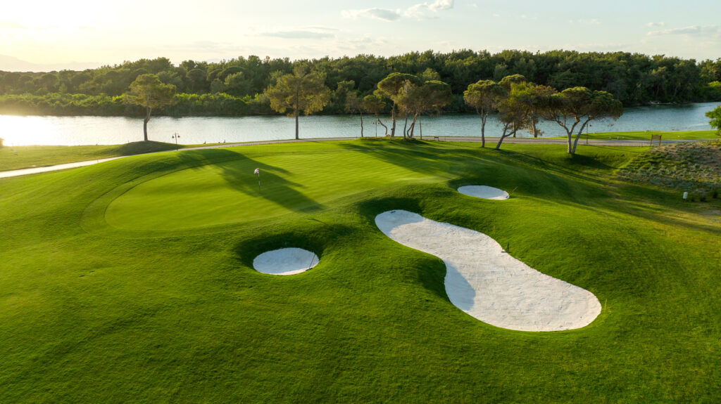 Hole with bunkers around with lake in background at Cullinan - Olympos Golf Course