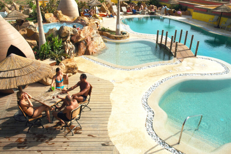 People relaxing by the outdoor pool at Desert Springs The Lodge Hotel