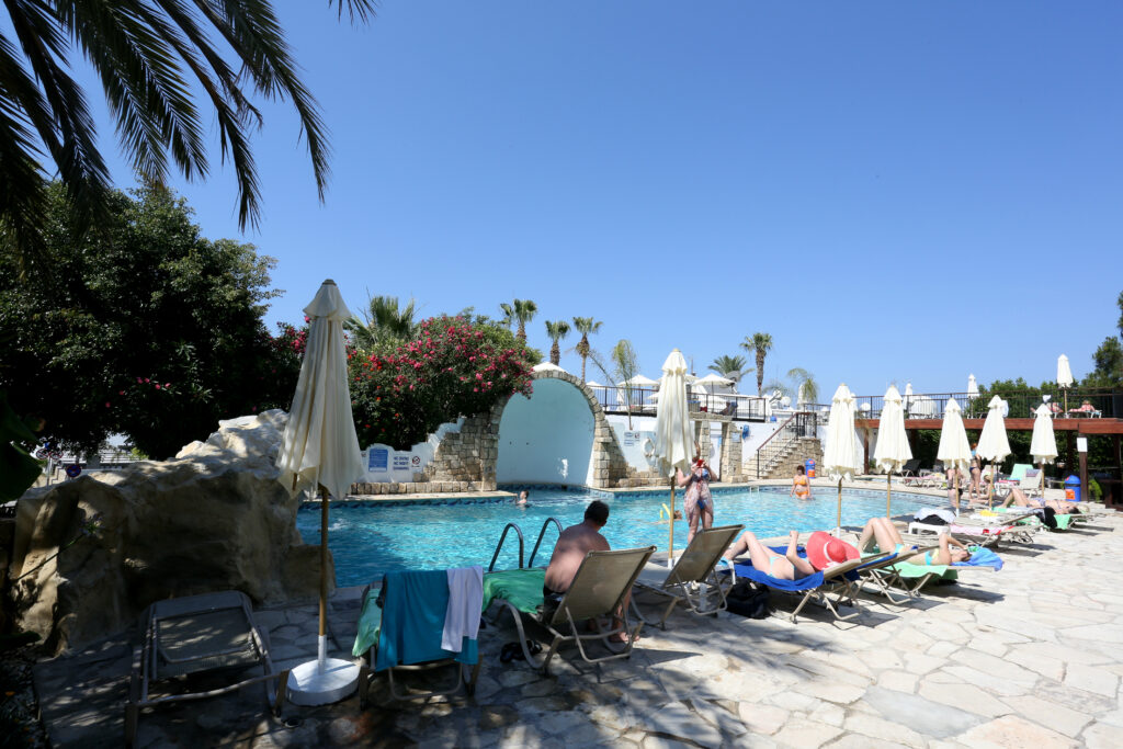 Outdoor pool at Dionysos Central with sun loungers