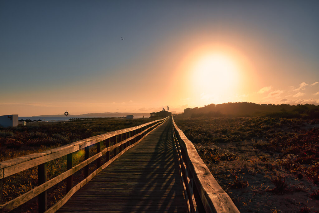Boarded path through the beach at Domes Lakes Algarve at sunset