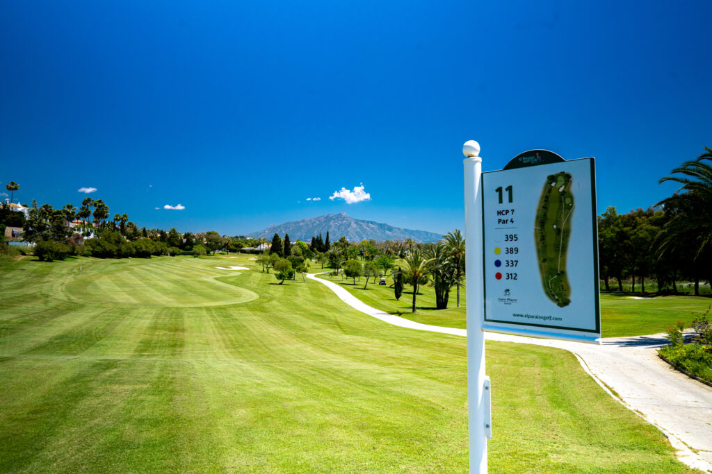 11th hole at El Paraiso Golf Course with trees and hill in background