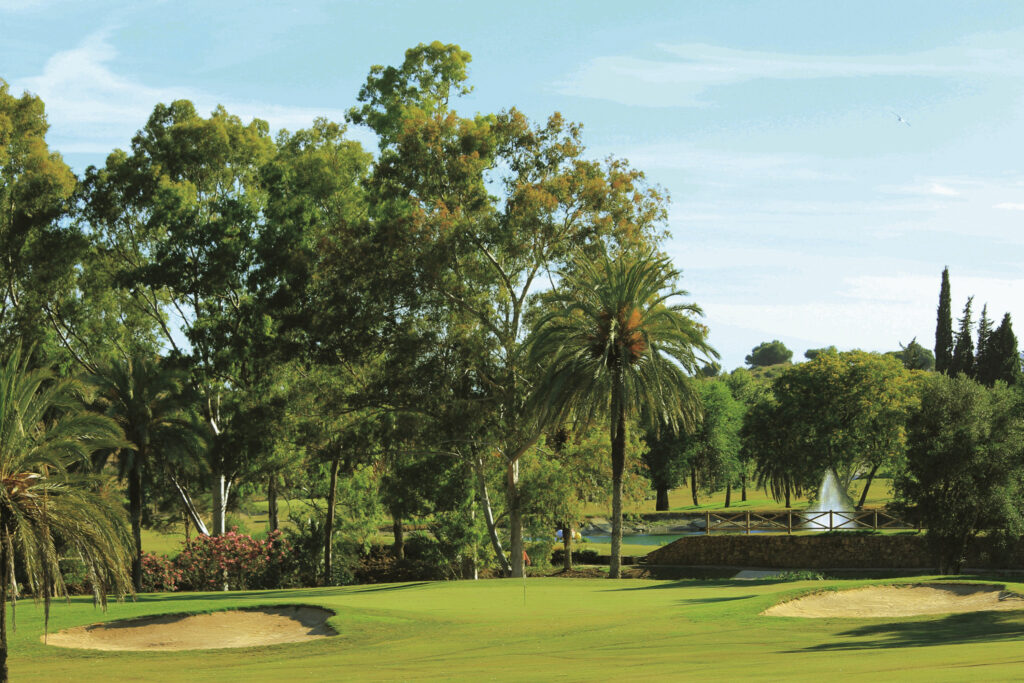 Hole with bunkers at El Paraiso Golf Course with trees around