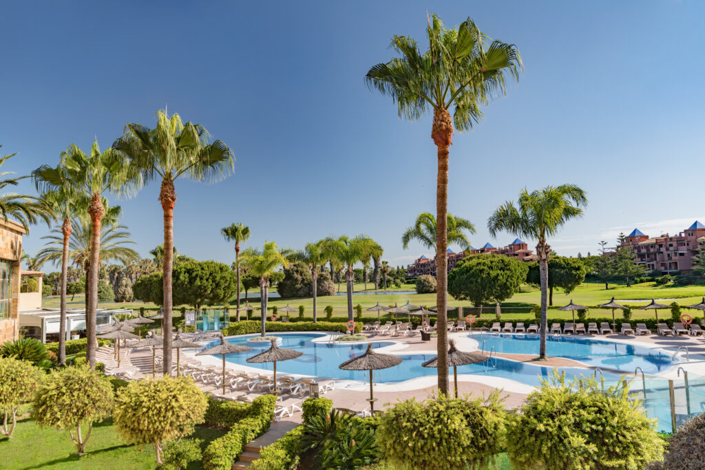 Outdoor pool with palm trees at Elba Costa Ballena