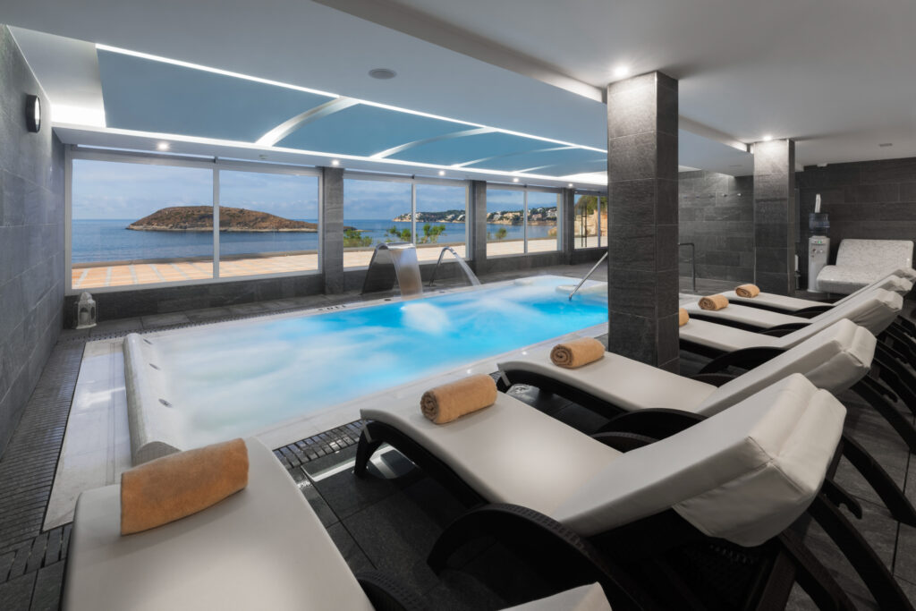 Indoor pool with loungers and fountains at Elba Sunset Mallorca Thalasso Spa Hotel