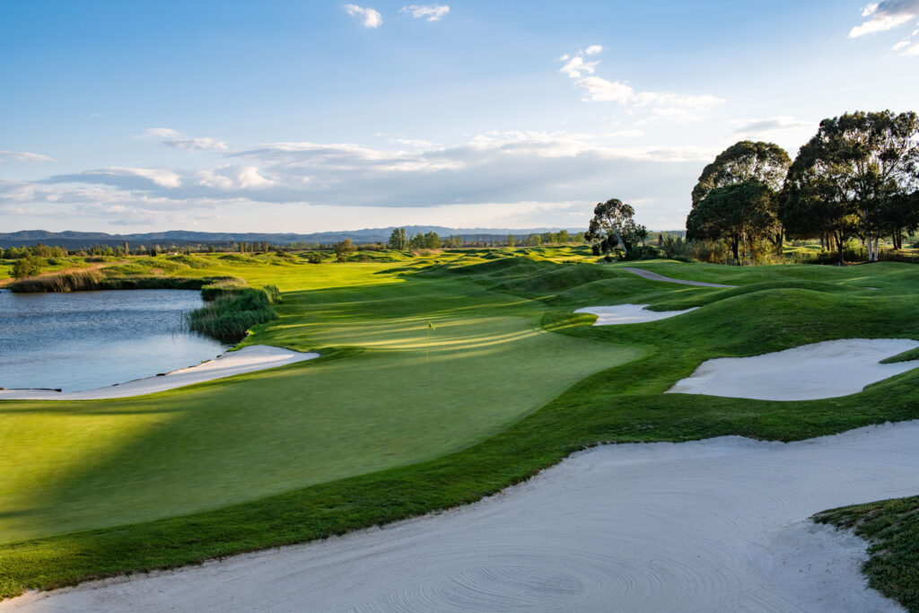 Fairway with bunkers and a lake at Emporda - Links Course