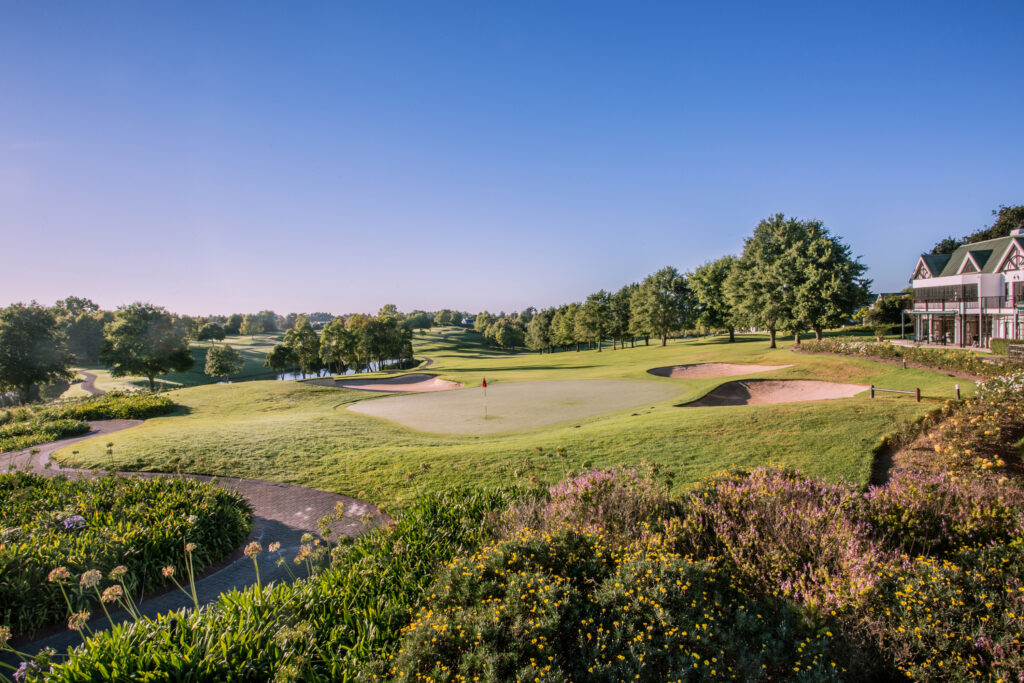 Hole with bunkers at Fancourt Hotel with trees around