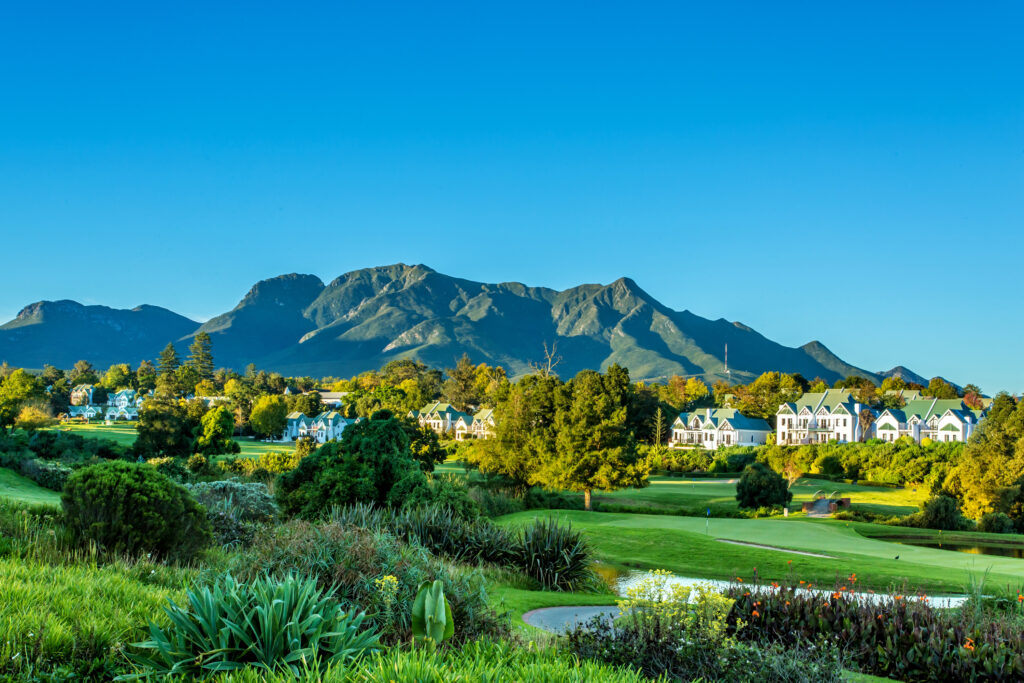 Fairway at Fancourt Hotel with buildings and mountains in distance