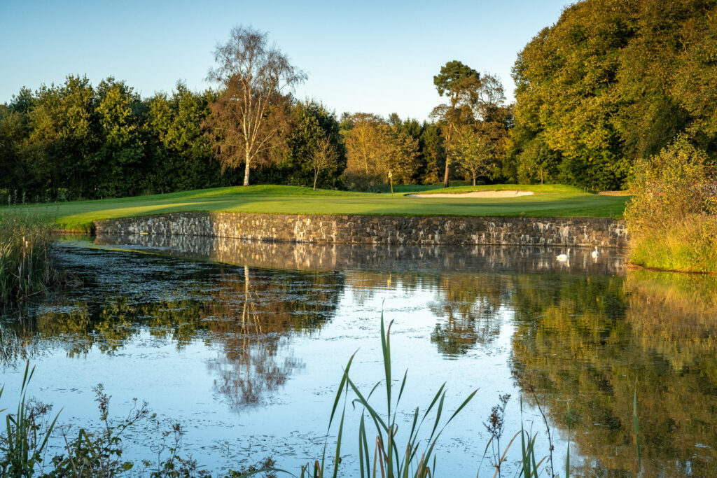 Lake on fairway at Galgorm Championship Course with trees and hole in background