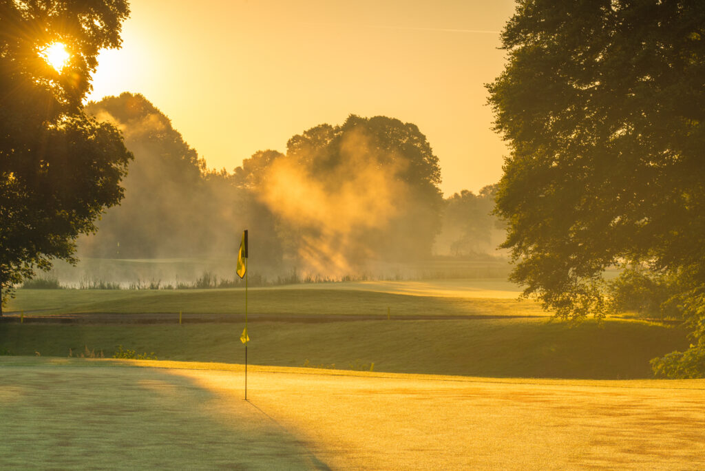 Hole at Galgorm Championship Course with trees around at sunset