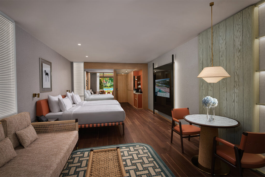 A superior laguna room, with a minimalistic but modern style. A spacious room with large beds and a sofa and seating area with a flat screen tv incorporated into the wall of the room.