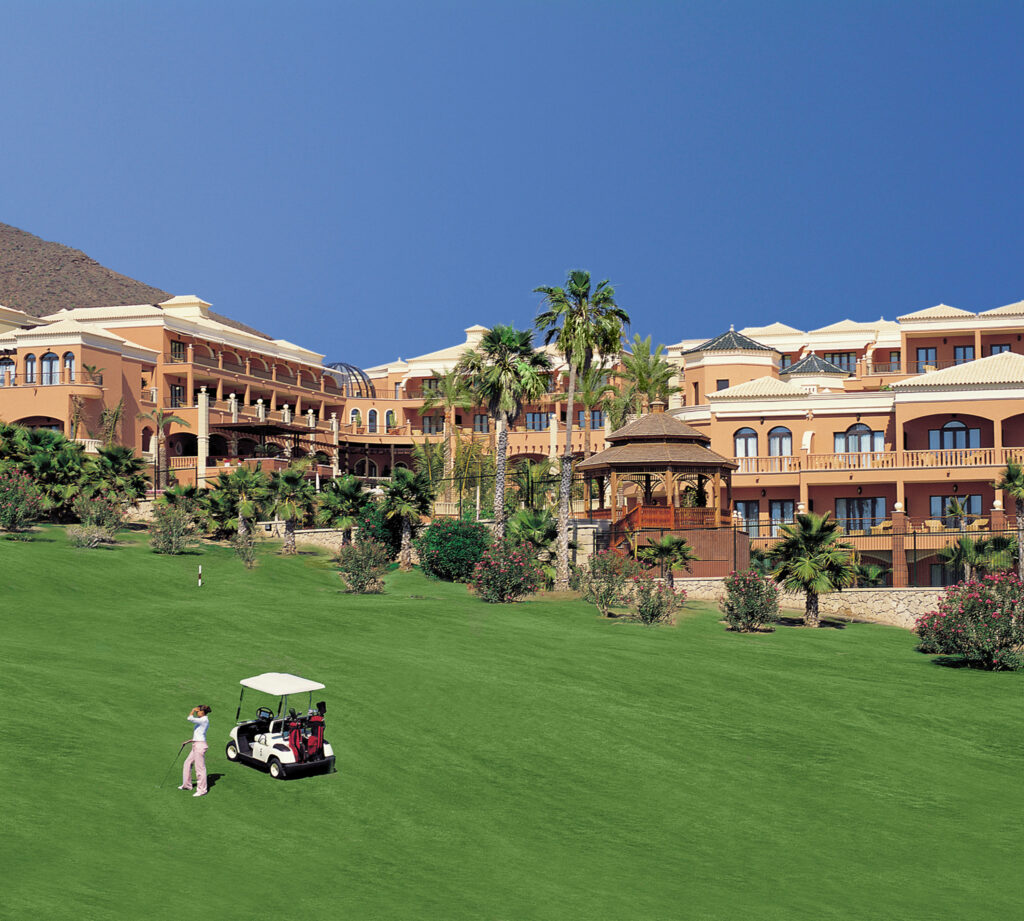 Person playing golf at Golf Las Americas with buildings in background