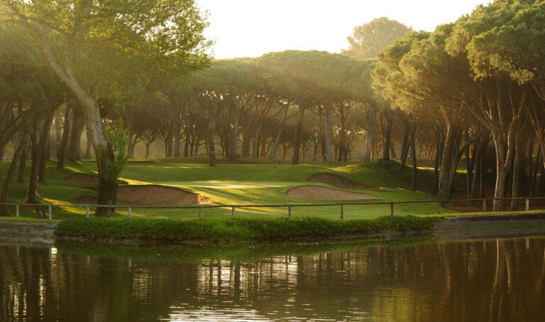 Fairway with lake and trees around at Golf de Pals Course