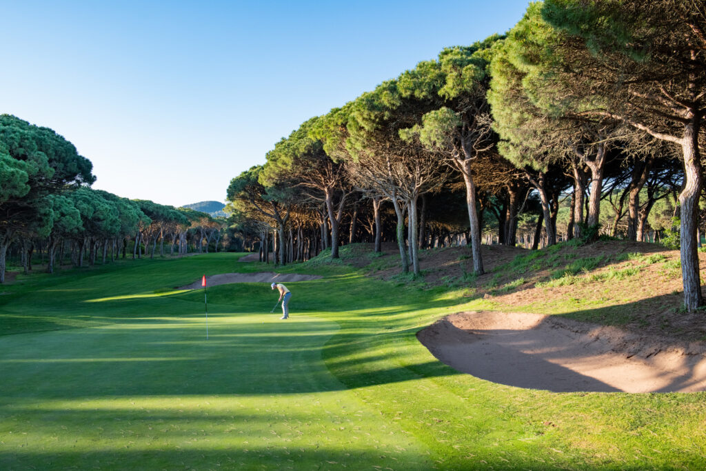 Person playing golf at Golf de Pals Course with trees around