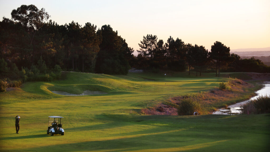 Man playing golf on the fairway with a buggy at Guardian Bom Sucesso