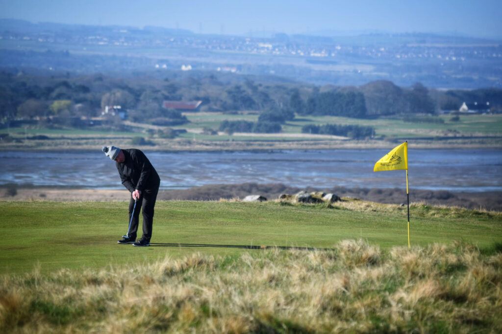 Person playing golf at Gullane Golf Club – No. 3 Course with a yellow flag