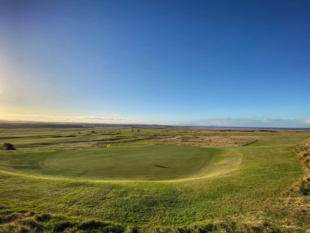 Hole with yellow flag at Gullane Golf Club – No. 3 Course with fairway around