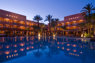 View of the outdoor pool at night at the Hotel Du Golf Rotana