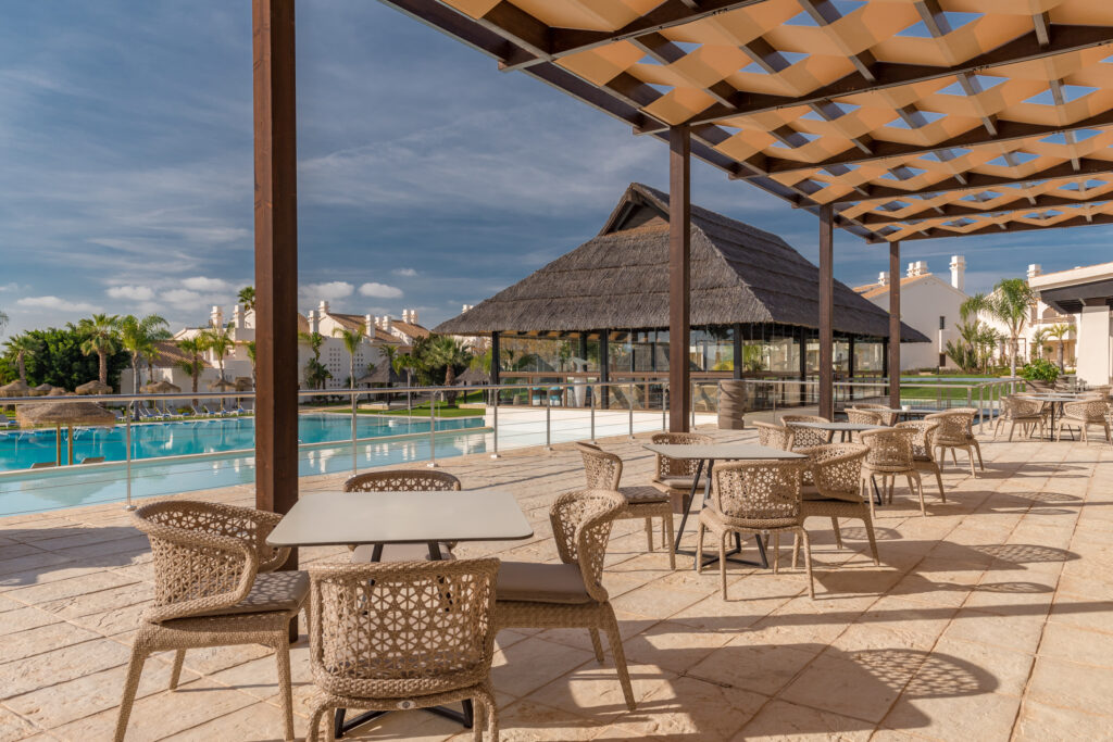 Seating by outdoor pool at Hacienda Del Alamo Golf Resort