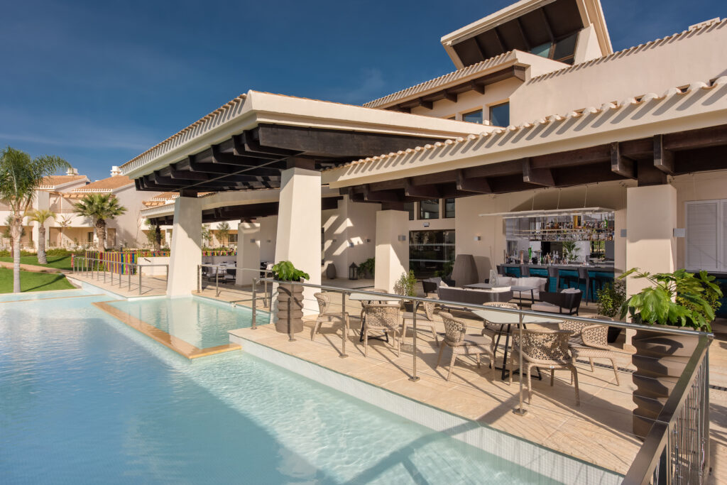 Outdoor pool with bar at Hacienda Del Alamo Golf Resort