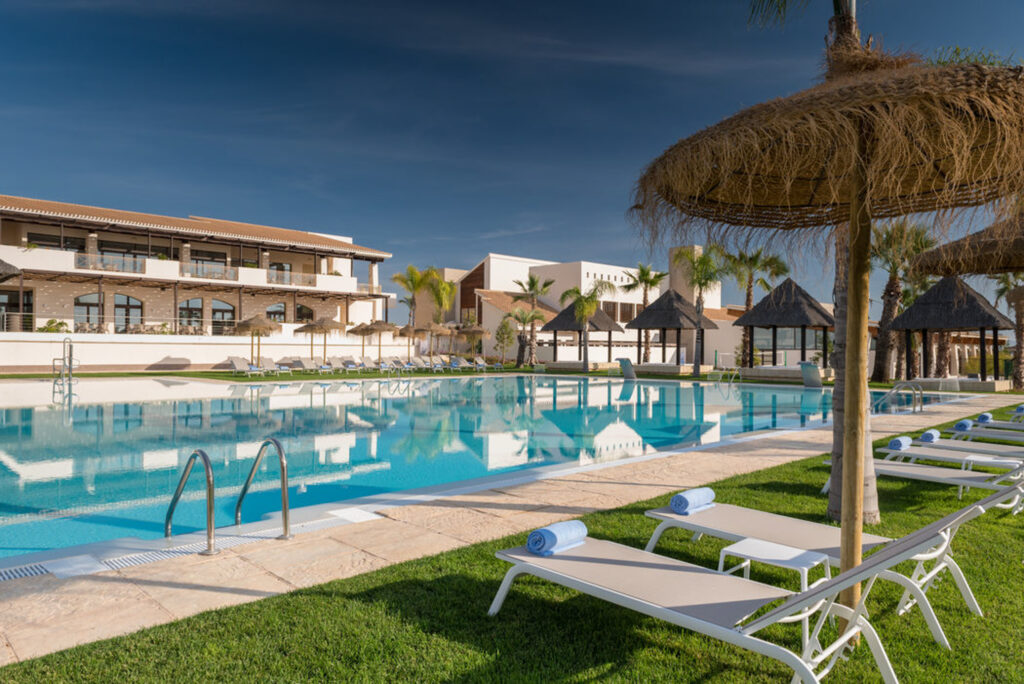 Outdoor pool with loungers at Hacienda Del Alamo Golf Resort