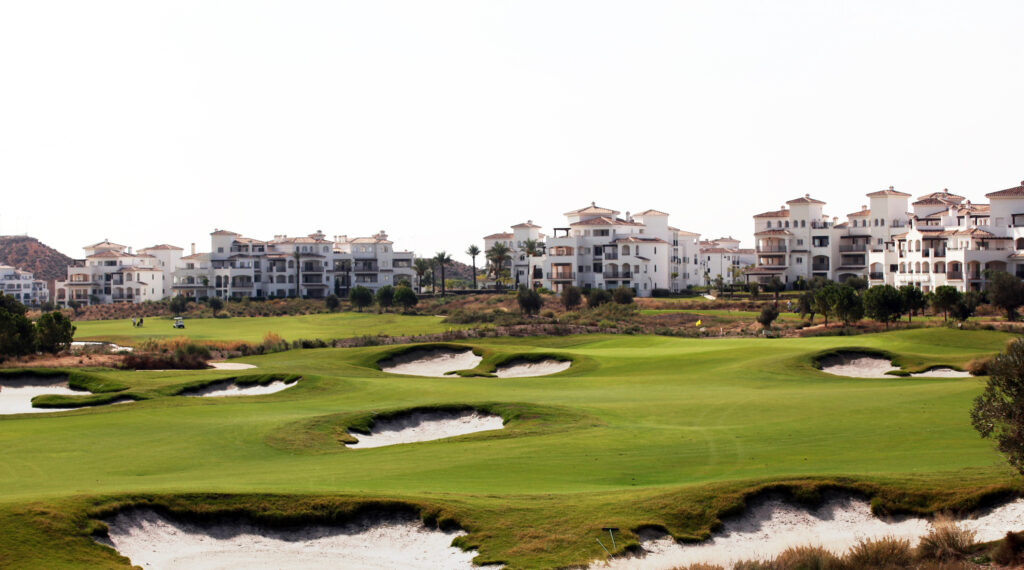 Bunkers on fairway with buildings in background at Hacienda Riquelme Golf Course