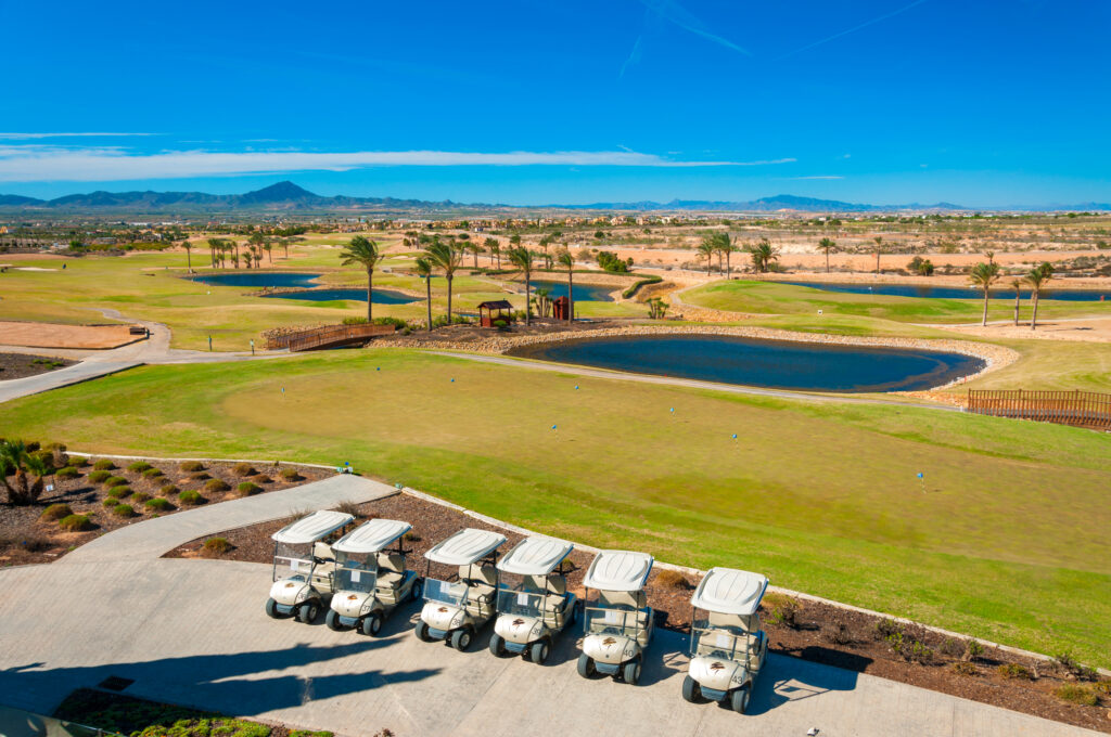 Buggies with Hacienda del Alamo Golf Course in the background