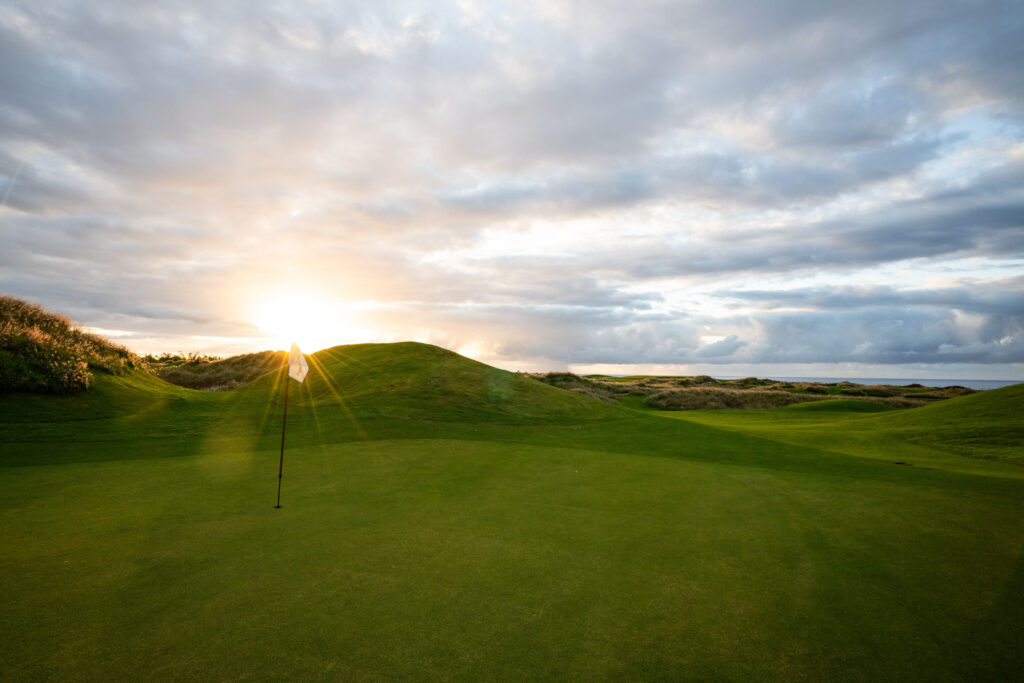 Hole with white flag at Heritage Golf Club - La Reserve Golf Links with sun shining