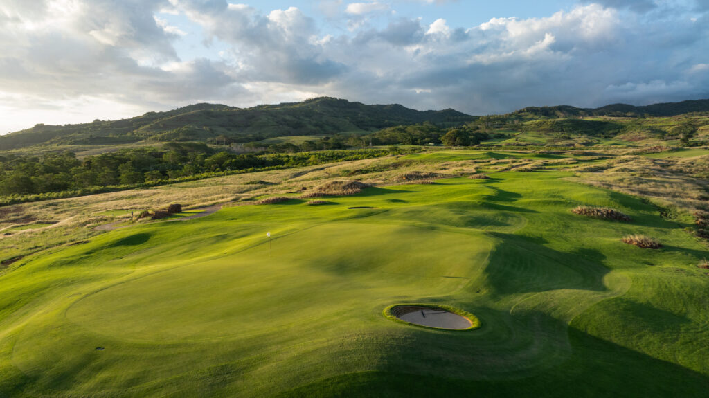 Hole with bunker at Heritage Golf Club - La Reserve Golf Links with hills in background