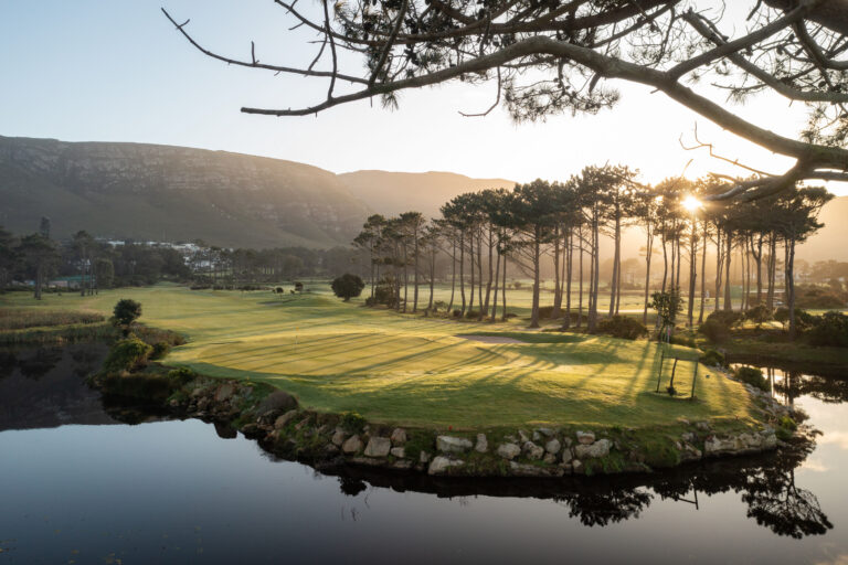 Hole at Hermanus Golf Club with trees around and mountains in distance