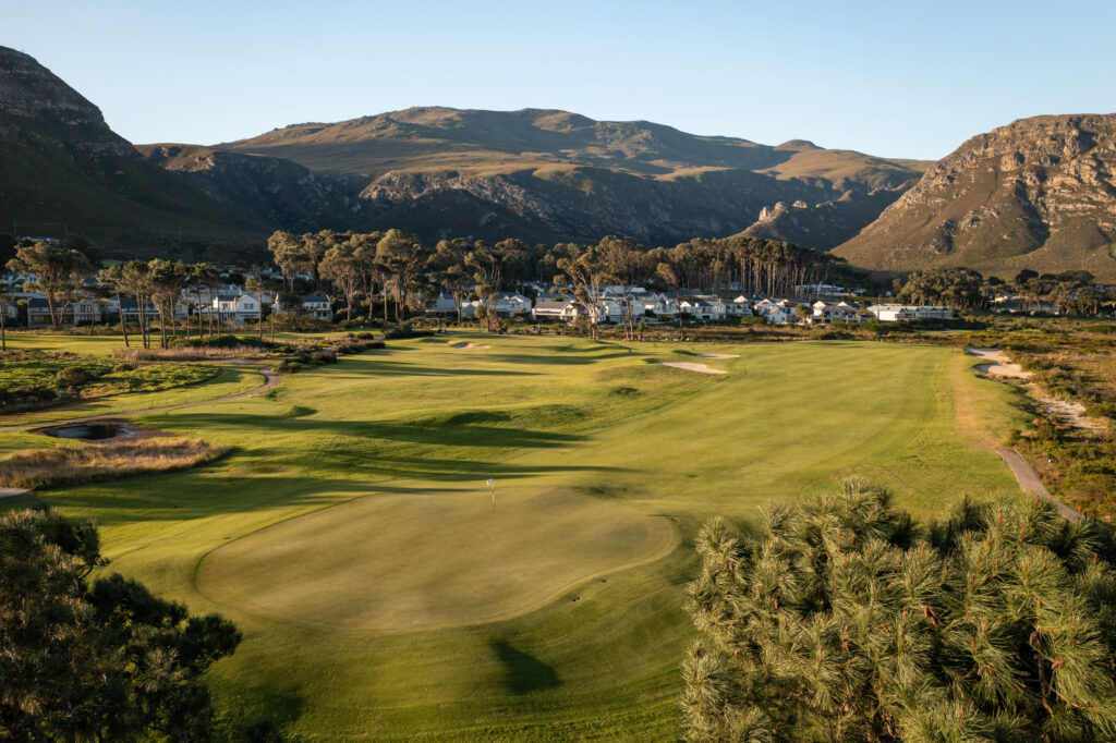 Hole with trees around at Hermanus Golf Club with mountains in distance