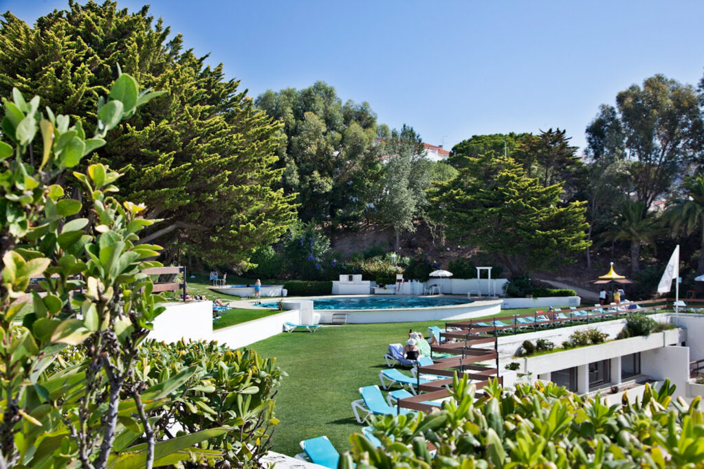 Outdoor seating area and pool at Hotel do Mar